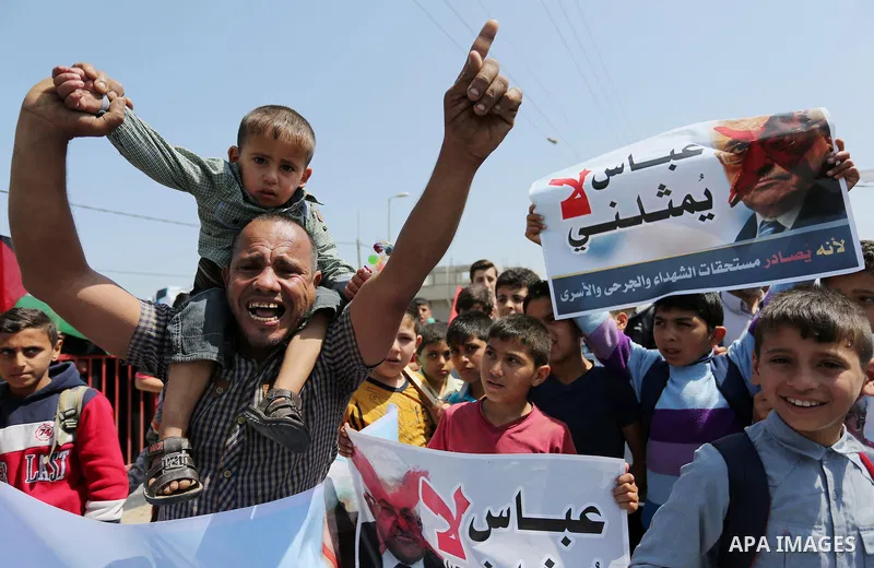 Palestinians hold a poster depicting Palestinian President Mahmoud Abbas during a protest against the blockade in Dair Al Balah, in the center of Gaza strip on May 2, 2017 demanding an end to the one-decade-old Israeli s...