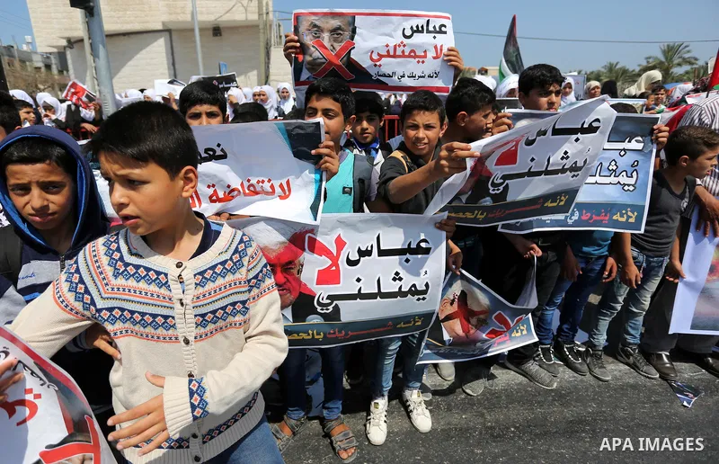 Palestinians hold a poster depicting Palestinian President Mahmoud Abbas during a protest against the blockade in Dair Al Balah, in the center of Gaza strip on May 2, 2017 demanding an end to the one-decade-old Israeli s...