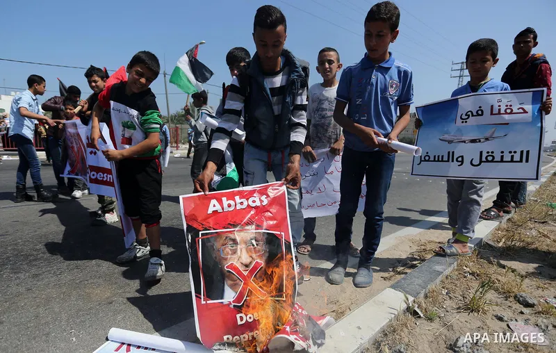 Palestinians hold a poster depicting Palestinian President Mahmoud Abbas during a protest against the blockade in Dair Al Balah, in the center of Gaza strip on May 2, 2017 demanding an end to the one-decade-old Israeli s...
