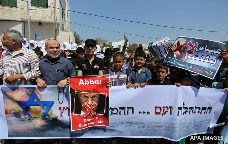 Palestinians hold a poster depicting Palestinian President Mahmoud Abbas during a protest against the blockade in Dair Al Balah, in the center of Gaza strip on May 2, 2017 demanding an end to the one-decade-old Israeli s...