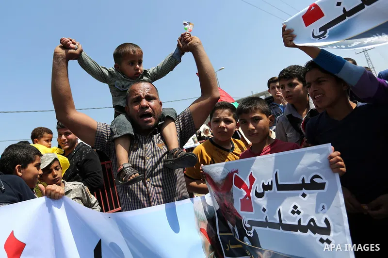 Palestinians hold a poster depicting Palestinian President Mahmoud Abbas during a protest against the blockade in Dair Al Balah, in the center of Gaza strip on May 2, 2017 demanding an end to the one-decade-old Israeli s...
