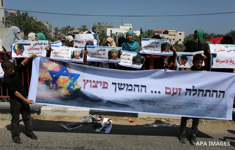 Palestinians hold a poster depicting Palestinian President Mahmoud Abbas during a protest against the blockade in Dair Al Balah, in the center of Gaza strip on May 2, 2017 demanding an end to the one-decade-old Israeli s...