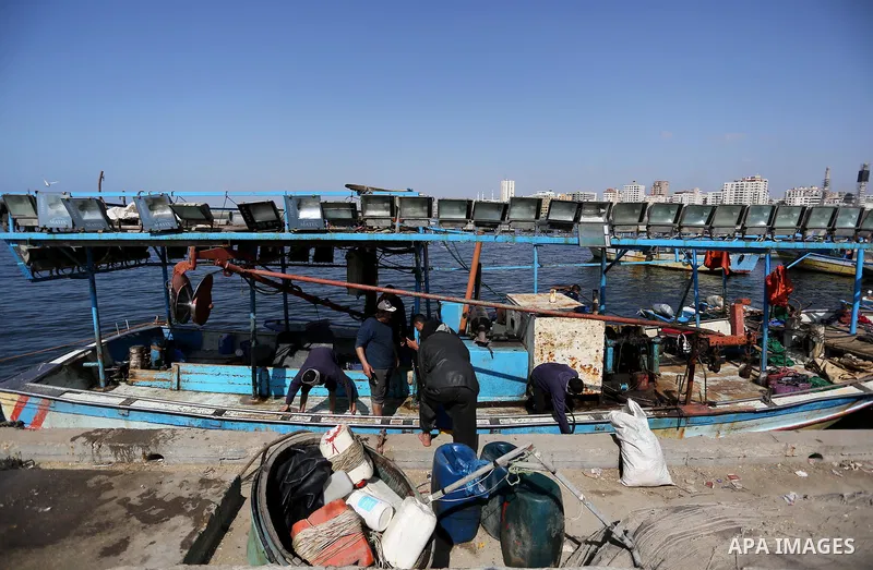 Palestinian fishermen work on their fishing boat at the beach of Gaza City, on May 03, 2017. Israel has eased restrictions on Gaza fishermen, allowing them to travel up to nine nautical miles off the coast of the blockad...