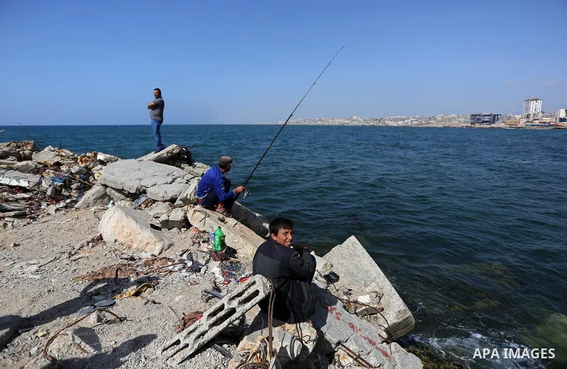 A Palestinian man uses a hook to fishing at the beach of Gaza City, on May 03, 2017. Israel has eased restrictions on Gaza fishermen, allowing them to travel up to nine nautical miles off the coast of the blockaded terri...
