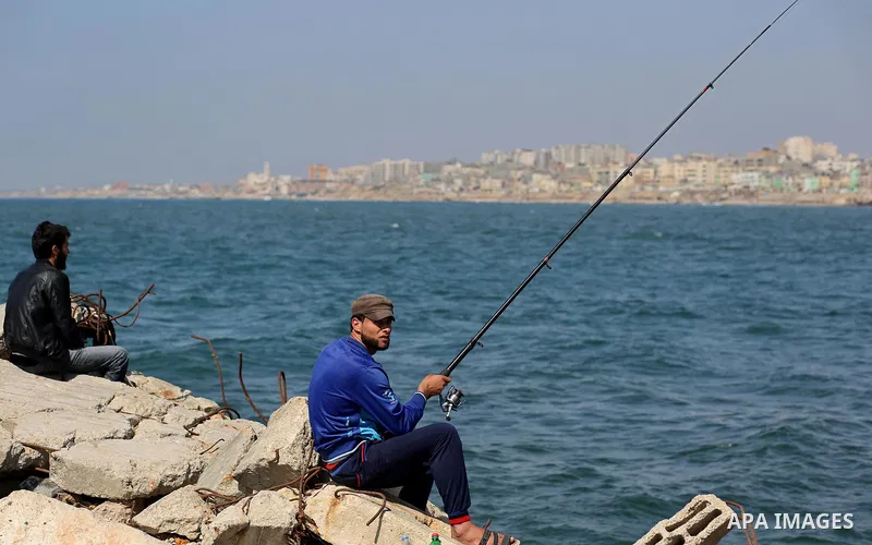 A Palestinian man uses a hook to fishing at the beach of Gaza City, on May 03, 2017. Israel has eased restrictions on Gaza fishermen, allowing them to travel up to nine nautical miles off the coast of the blockaded terri...