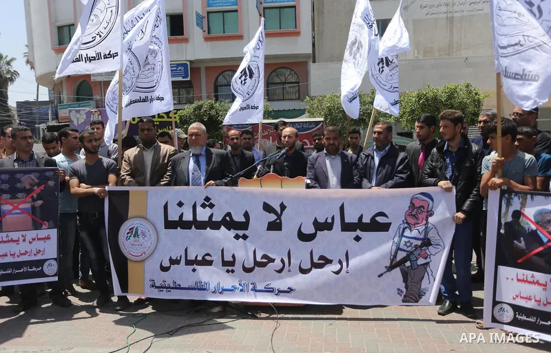 Palestinians hold a poster depicting Palestinian President Mahmoud Abbas during a protest against the blockade, in Gaza city, on May 4, 2017. Photo by Mohammed Asad
