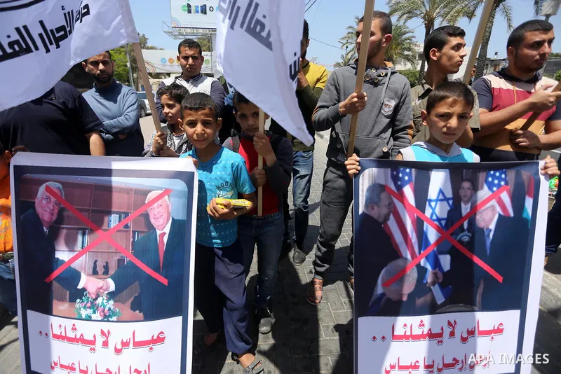 Palestinians hold a poster depicting Palestinian President Mahmoud Abbas during a protest against the blockade, in Gaza city, on May 4, 2017. Photo by Mohammed Asad