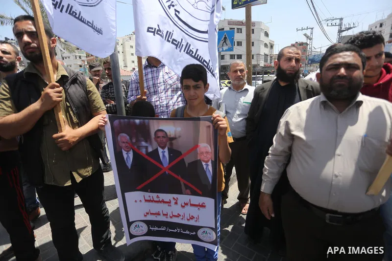 Palestinians hold a poster depicting Palestinian President Mahmoud Abbas during a protest against the blockade, in Gaza city, on May 4, 2017. Photo by Mohammed Asad