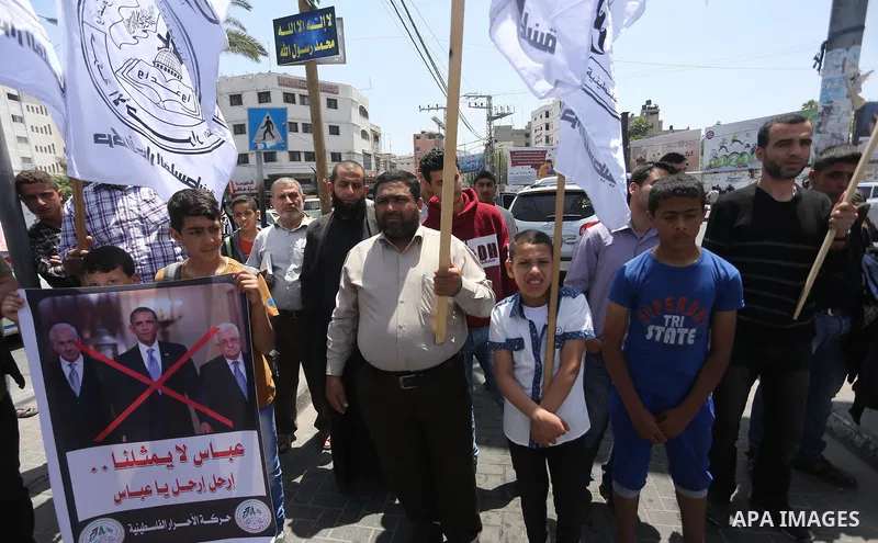 Palestinians hold a poster depicting Palestinian President Mahmoud Abbas during a protest against the blockade, in Gaza city, on May 4, 2017. Photo by Mohammed Asad