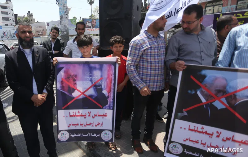 Palestinians hold a poster depicting Palestinian President Mahmoud Abbas during a protest against the blockade, in Gaza city, on May 4, 2017. Photo by Mohammed Asad
