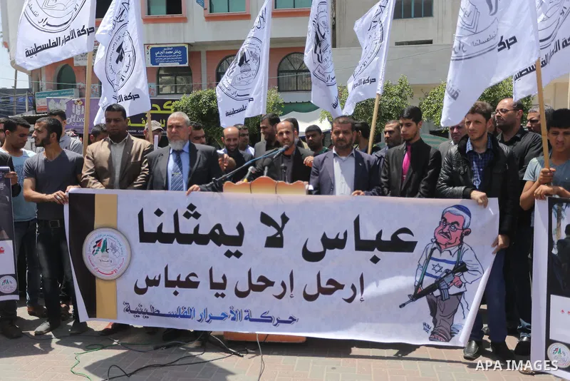Palestinians hold a poster depicting Palestinian President Mahmoud Abbas during a protest against the blockade, in Gaza city, on May 4, 2017. Photo by Mohammed Asad