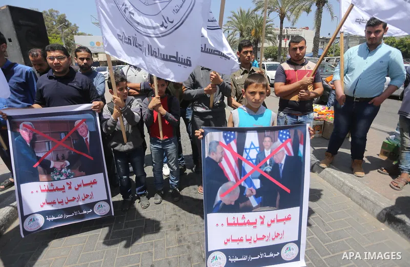 Palestinians hold a poster depicting Palestinian President Mahmoud Abbas during a protest against the blockade, in Gaza city, on May 4, 2017. Photo by Mohammed Asad