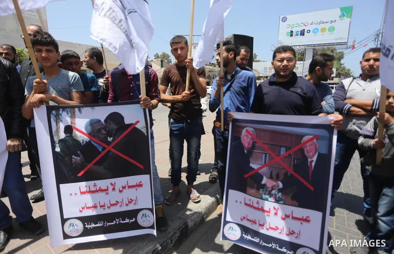Palestinians hold a poster depicting Palestinian President Mahmoud Abbas during a protest against the blockade, in Gaza city, on May 4, 2017. Photo by Mohammed Asad
