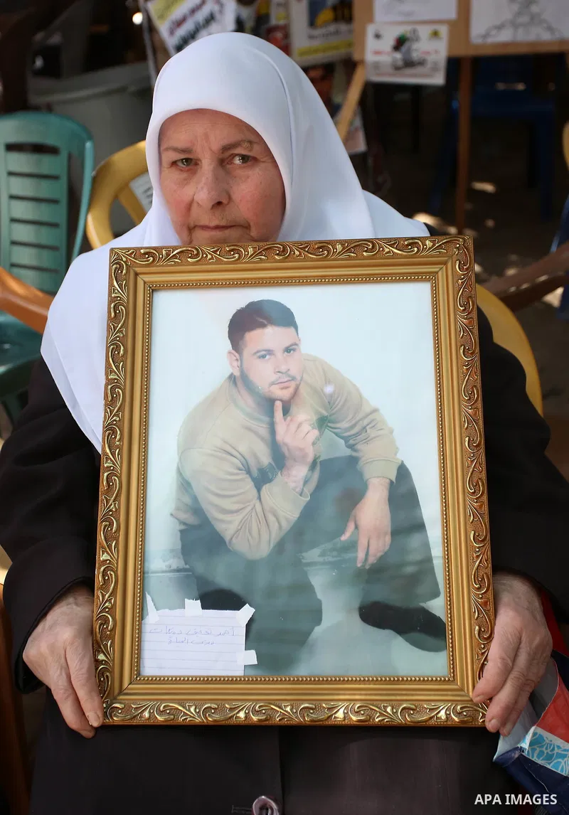 A Palestinian woman holds a picture of her son who held in Israeli jails at a protest tent in support of Palestinian prisoners on hunger strike in Israeli jails, in the West Bank city of Nablus, on May 4, 2017. Photo by...
