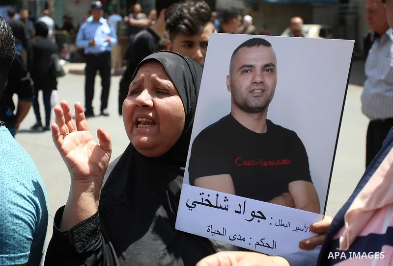 A Palestinian woman holds a picture of her son who held in Israeli jails at a protest tent in support of Palestinian prisoners on hunger strike in Israeli jails, in the West Bank city of Nablus, on May 4, 2017. Photo by...