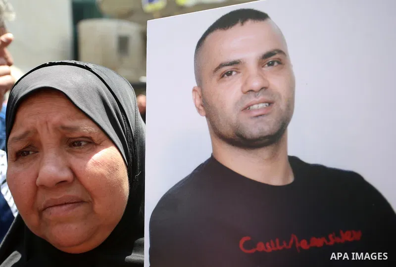 A Palestinian woman holds a picture of her son who held in Israeli jails at a protest tent in support of Palestinian prisoners on hunger strike in Israeli jails, in the West Bank city of Nablus, on May 4, 2017. Photo by...