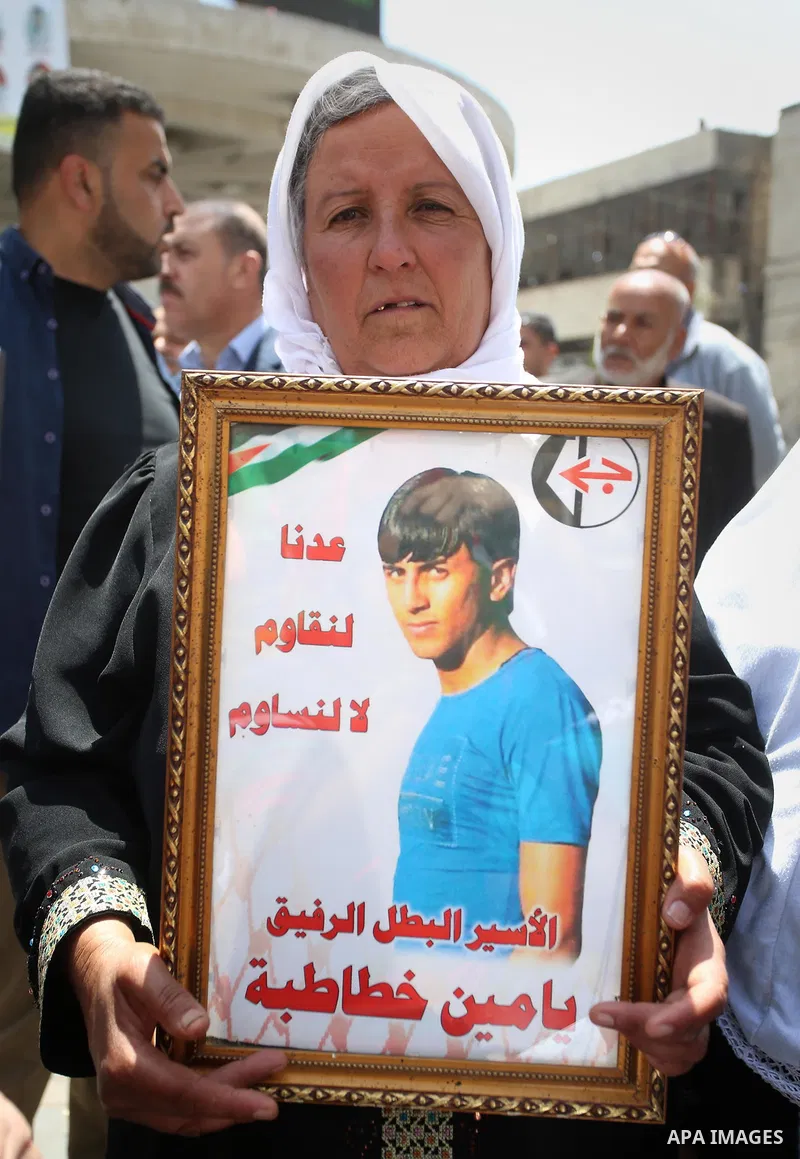A Palestinian woman holds a picture of her son who held in Israeli jails at a protest tent in support of Palestinian prisoners on hunger strike in Israeli jails, in the West Bank city of Nablus, on May 4, 2017. Photo by...
