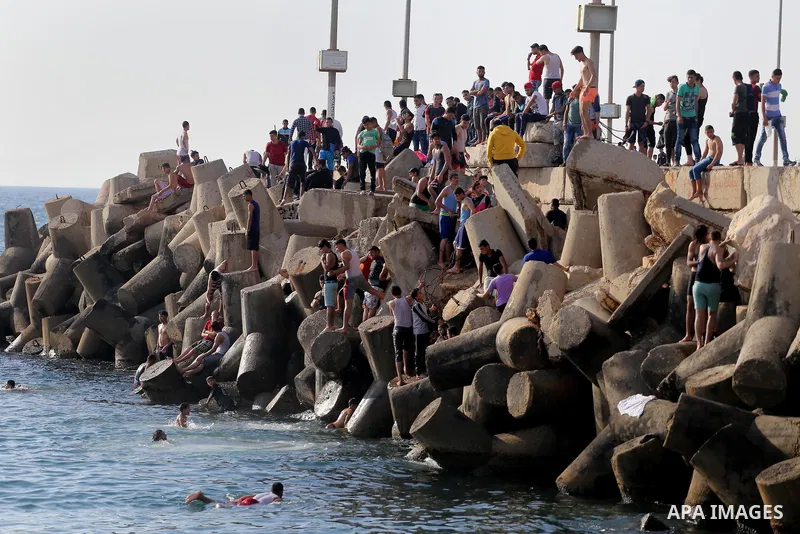 Palestinian youths swim as they enjoy in the Mediterranean Sea off the coast of Gaza City on May 5, 2017. Photo by Mohammed Asad
