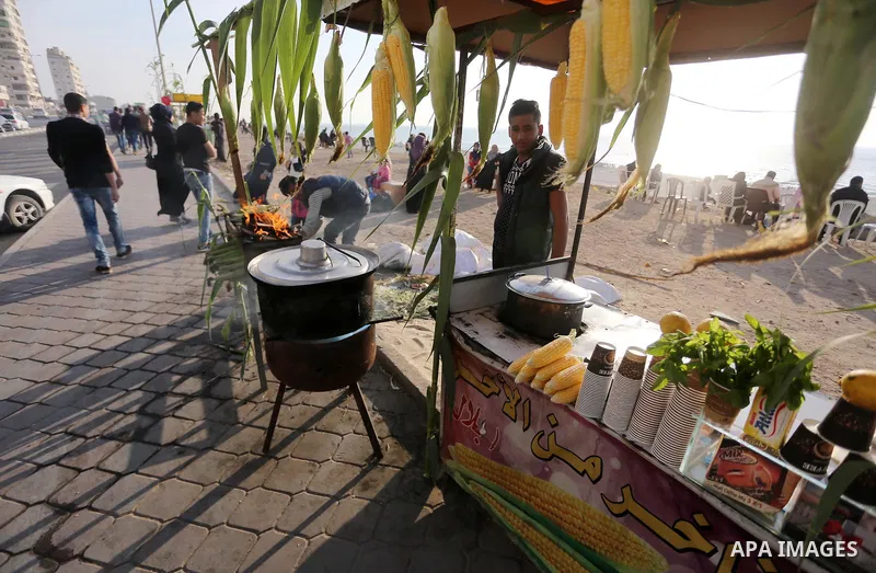 A Palestinian vendor sells corn off the beach of Gaza City on May 5, 2017. Photo by Mohammed Asad