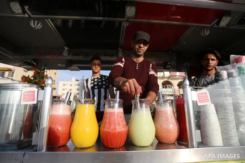 A Palestinian vendor sells juices off the beach of Gaza City on May 5, 2017. Photo by Mohammed Asad