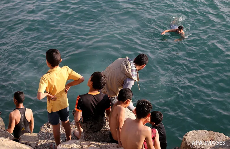 Palestinian youths swim as they enjoy in the Mediterranean Sea off the coast of Gaza City on May 5, 2017. Photo by Mohammed Asad