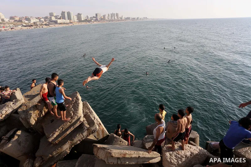 A Palestinian youth jumps into the Mediterranean Sea at the Gaza seaport in Gaza City on May 5, 2017. Photo by Mohammed Asad