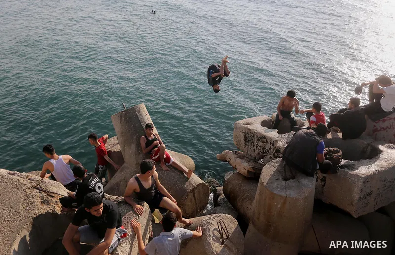 A Palestinian youth jumps into the Mediterranean Sea at the Gaza seaport in Gaza City on May 5, 2017. Photo by Mohammed Asad