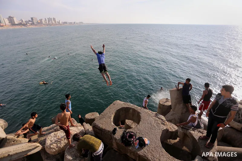 A Palestinian youth jumps into the Mediterranean Sea at the Gaza seaport in Gaza City on May 5, 2017. Photo by Mohammed Asad