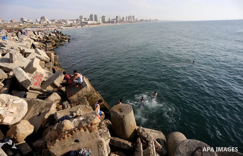 Palestinian youths swim as they enjoy in the Mediterranean Sea off the coast of Gaza City on May 5, 2017. Photo by Mohammed Asad