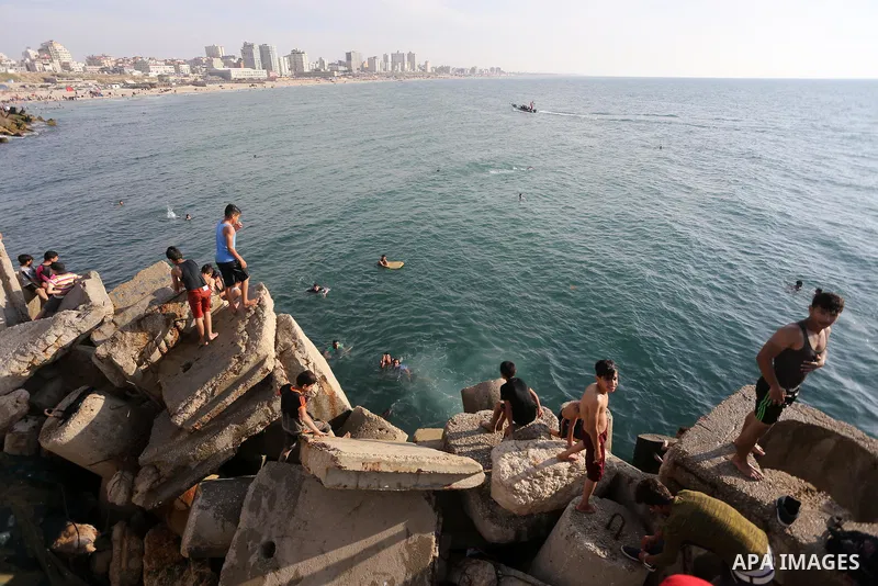 Palestinian youths swim as they enjoy in the Mediterranean Sea off the coast of Gaza City on May 5, 2017. Photo by Mohammed Asad