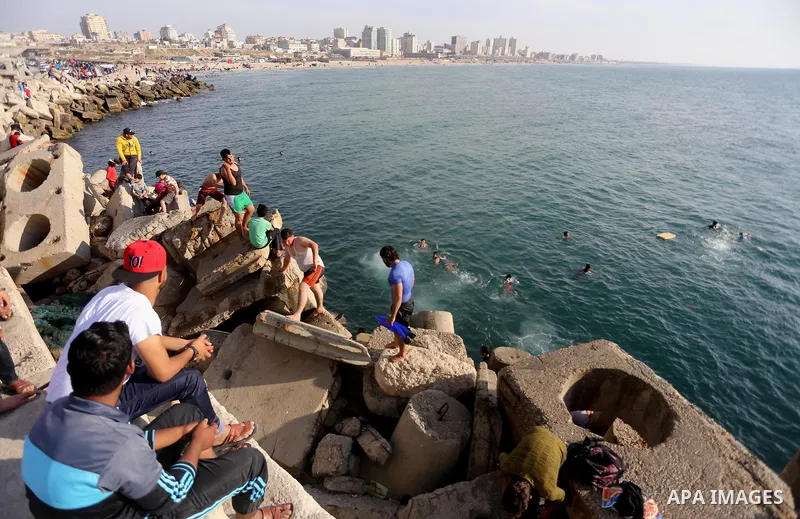 Palestinian youths swim as they enjoy in the Mediterranean Sea off the coast of Gaza City on May 5, 2017. Photo by Mohammed Asad