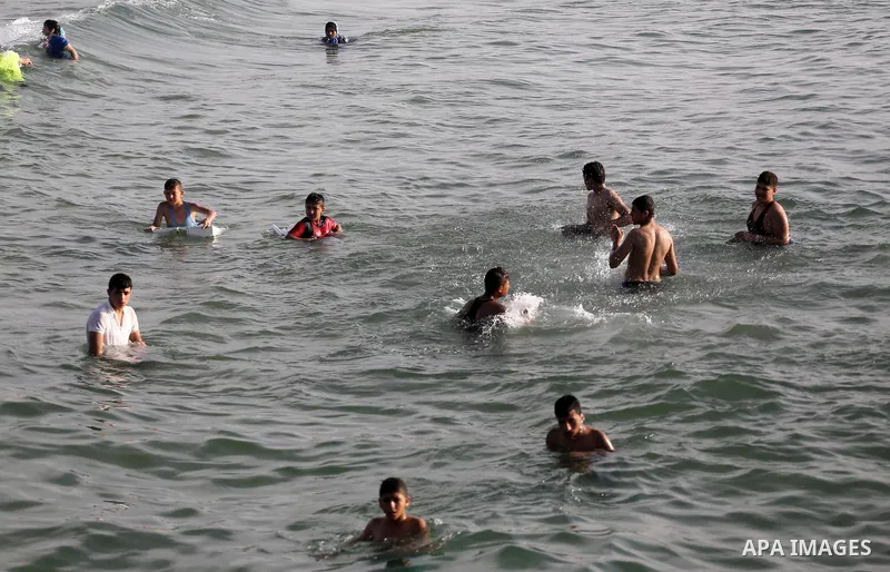 Palestinian youths swim as they enjoy in the Mediterranean Sea off the coast of Gaza City on May 5, 2017. Photo by Mohammed Asad