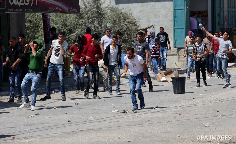 Palestinian protesters hurl stones towards Israeli security forces during clashes at a protest in support of Palestinian prisoners on hunger strike in Israeli jails, in the West Bank village of Beita, near Nablus May 5,...