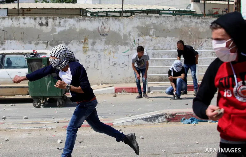 Palestinian protesters hurl stones towards Israeli security forces during clashes at a protest in support of Palestinian prisoners on hunger strike in Israeli jails, in the West Bank village of Beita, near Nablus May 5,...