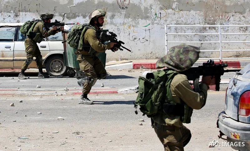 Israeli security forces aim their weapons towards Palestinian protesters during clashes at a protest in support of Palestinian prisoners on hunger strike in Israeli jails, in the West Bank village of Beita, near Nablus M...