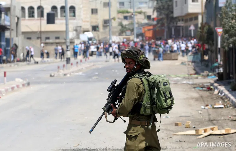 A member of Israeli security forces takes position during clashes with Palestinian protesters at a protest in support of Palestinian prisoners on hunger strike in Israeli jails, in the West Bank village of Beita, near Na...