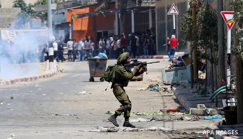 A member of Israeli security forces takes position during clashes with Palestinian protesters at a protest in support of Palestinian prisoners on hunger strike in Israeli jails, in the West Bank village of Beita, near Na...
