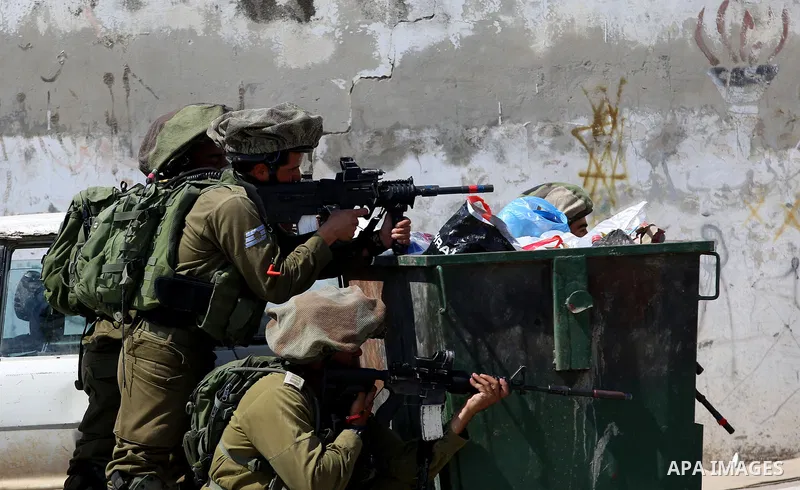 Israeli security forces aim their weapons towards Palestinian protesters during clashes at a protest in support of Palestinian prisoners on hunger strike in Israeli jails, in the West Bank village of Beita, near Nablus M...
