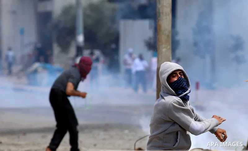 A Palestinian protester uses a slingshot to hurl stones towards Israeli security forces during clashes at a protest in support of Palestinian prisoners on hunger strike in Israeli jails, in the West Bank village of Beita...