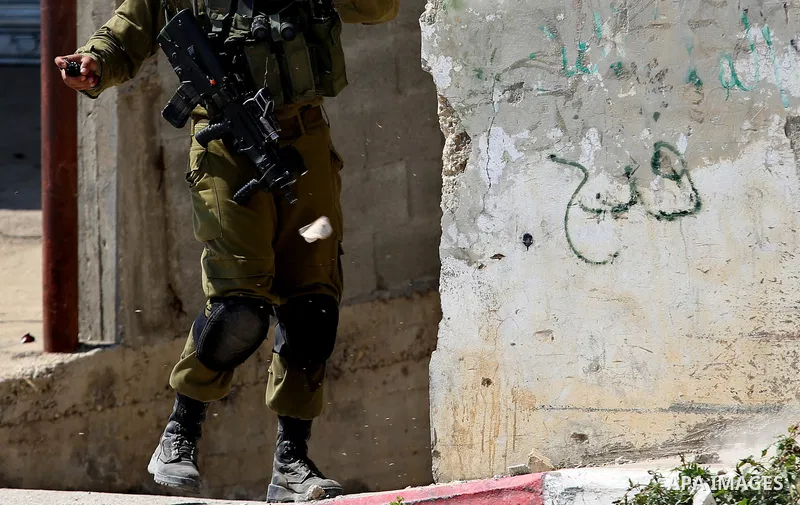 A member of Israeli security forces fires a tear gas canister towards Palestinian protesters during clashes at a protest in support of Palestinian prisoners on hunger strike in Israeli jails, in the West Bank village of...