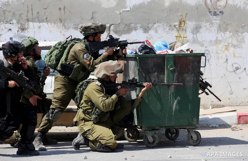 Israeli security forces aim their weapons towards Palestinian protesters during clashes at a protest in support of Palestinian prisoners on hunger strike in Israeli jails, in the West Bank village of Beita, near Nablus M...