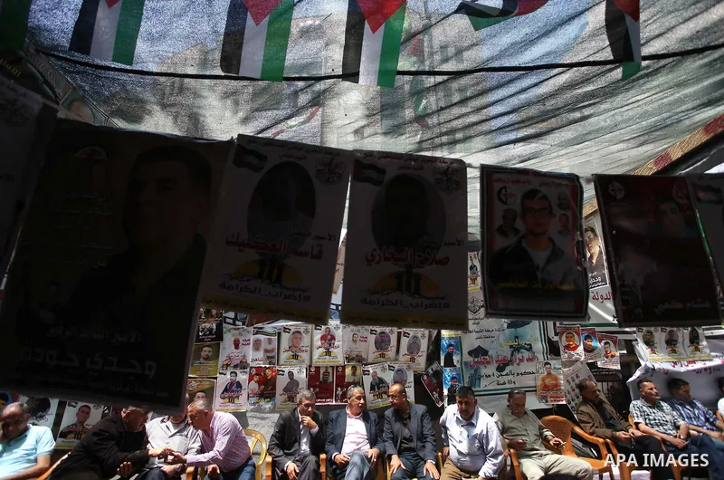 Palestinians hold placards as they take part at a protest tent in solidarity with Palestinian hunger-striking prisoners in Israeli jails, in the West Bank city of Nablus, on May 07, 2017. Photo by Ayman Ameen
