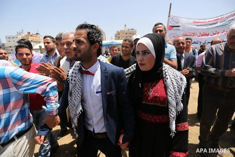 A Palestinian groom and his bride take part in their marriage ceremony at a sit-in in support of Palestinian hunger-striking prisoners held in Israeli jails, on May 8, 2017, in Gaza City. Photo by Ashraf Amra