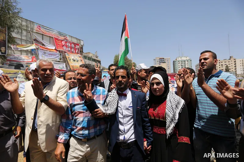 A Palestinian groom and his bride take part in their marriage ceremony at a sit-in in support of Palestinian hunger-striking prisoners held in Israeli jails, on May 8, 2017, in Gaza City. Photo by Ashraf Amra