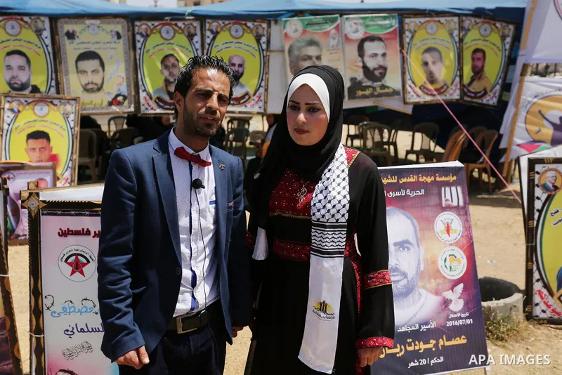A Palestinian groom and his bride take part in their marriage ceremony at a sit-in in support of Palestinian hunger-striking prisoners held in Israeli jails, on May 8, 2017, in Gaza City. Photo by Ashraf Amra