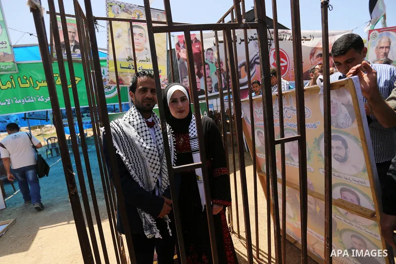 A Palestinian groom and his bride take part in their marriage ceremony at a sit-in in support of Palestinian hunger-striking prisoners held in Israeli jails, on May 8, 2017, in Gaza City. Photo by Ashraf Amra