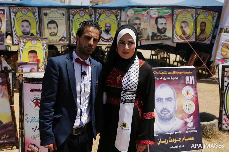 A Palestinian groom and his bride take part in their marriage ceremony at a sit-in in support of Palestinian hunger-striking prisoners held in Israeli jails, on May 8, 2017, in Gaza City. Photo by Ashraf Amra