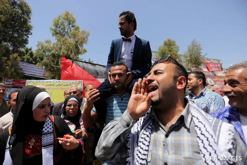 A Palestinian groom and his bride take part in their marriage ceremony at a sit-in in support of Palestinian hunger-striking prisoners held in Israeli jails, on May 8, 2017, in Gaza City. Photo by Ashraf Amra