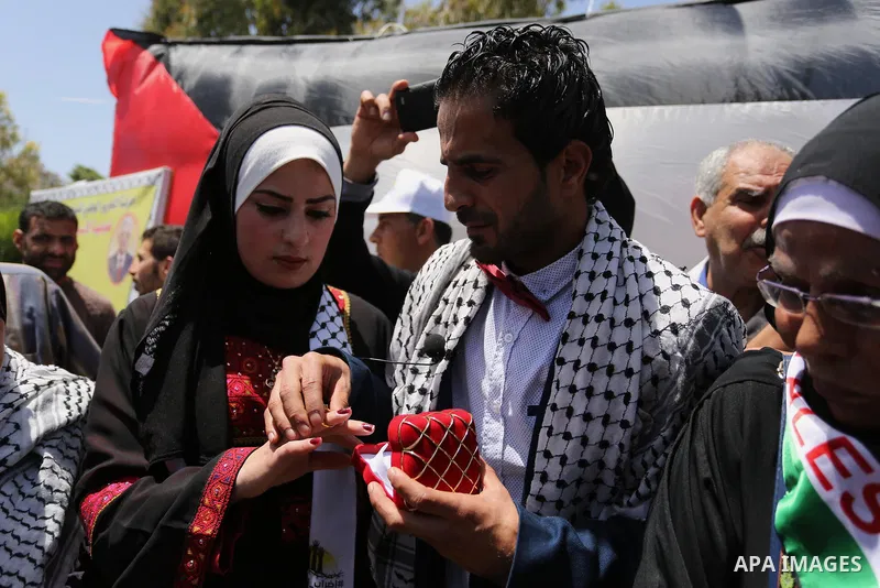 A Palestinian groom and his bride take part in their marriage ceremony at a sit-in in support of Palestinian hunger-striking prisoners held in Israeli jails, on May 8, 2017, in Gaza City. Photo by Ashraf Amra