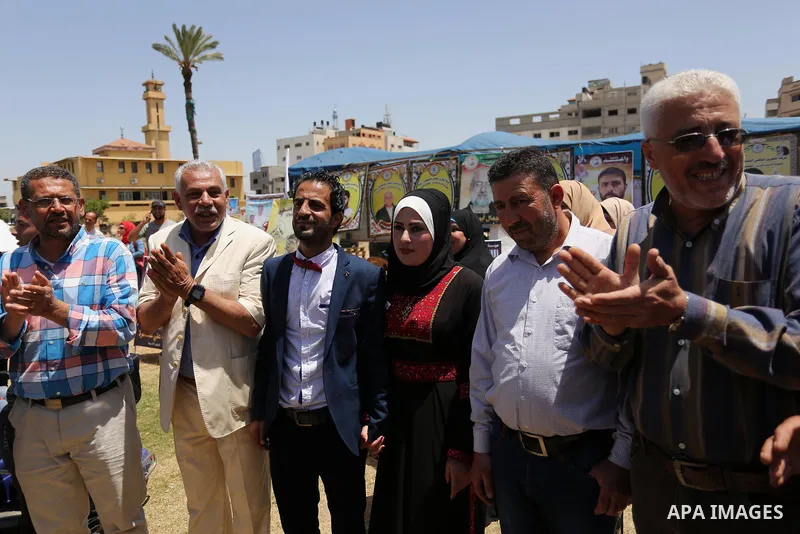 A Palestinian groom and his bride take part in their marriage ceremony at a sit-in in support of Palestinian hunger-striking prisoners held in Israeli jails, on May 8, 2017, in Gaza City. Photo by Ashraf Amra